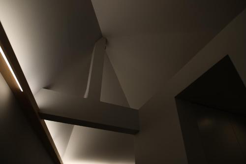 a stairwell in a room with a light on the ceiling at HIYASAI -LOGIN Kurashiki- in Kurashiki