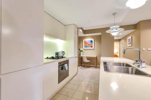 Darwin Waterfront Luxury Suites في داروين: مطبخ مع حوض وكاونتر