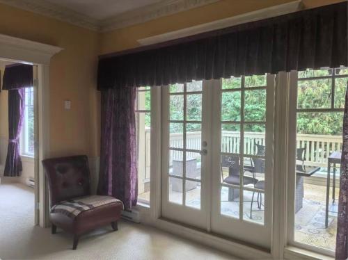 a living room with a sliding glass door with a balcony at Kerrisdale cozy house in Vancouver