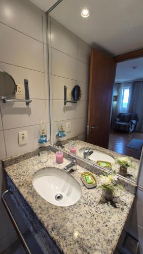 a bathroom counter with a sink and a mirror at Barra First Class in Rio de Janeiro