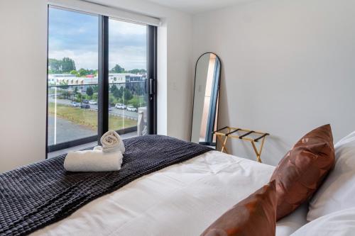 Un dormitorio con una cama y una ventana grande. en Manchester Square Urban Stay - Easy To Everything, en Christchurch
