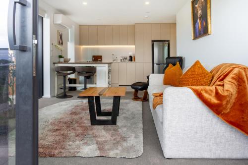 Una sala de estar con un sofá blanco y una mesa. en Manchester Square Urban Stay - Easy To Everything, en Christchurch