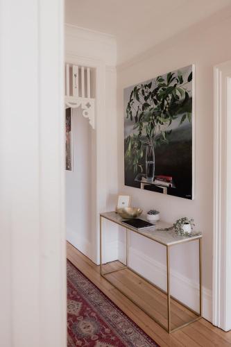a table in a room with a painting on the wall at 'Sobrina=' - A home away from home in Sandy Bay in Sandy Bay
