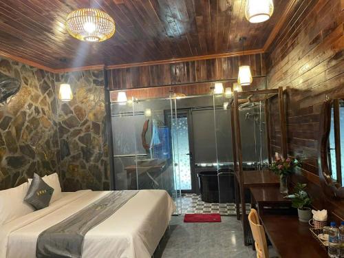 ein Schlafzimmer mit einem Bett und ein Badezimmer mit Dusche in der Unterkunft Trang An River Sunshine Bungalow in Xuân Sơn