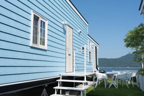 a patio with chairs and a table on the side of a house at 宮島リゾート Hauol'i in Hatsukaichi