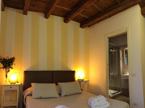 ヴェローナにあるStella Luxury Homeのベッドルーム1室(ストライプの壁とランプ2つ付)