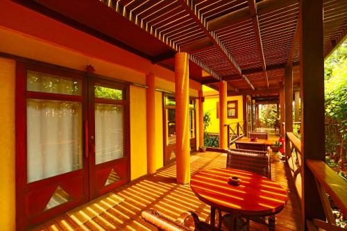 una terraza de madera con mesa y sillas. en Pousada Pedras Secas, en Fernando de Noronha