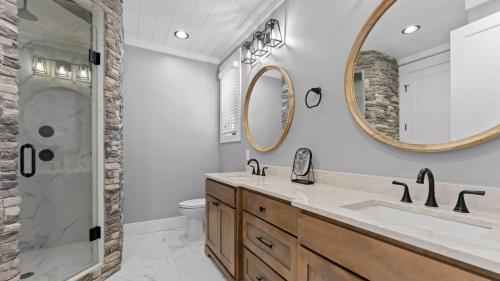 Luxe Lakefront Lodge w Pool Hot Tub Theater Private Dock Sleeps 22 في ليك نورمان أوف كاتاوبا: حمام مزود بحوض ومِرآة