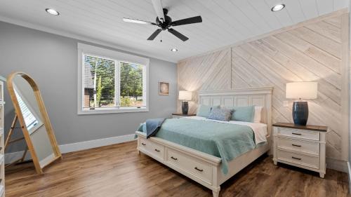 Luxe Lakefront Lodge w Pool Hot Tub Theater Private Dock Sleeps 22 في ليك نورمان أوف كاتاوبا: غرفة نوم بها سرير ومروحة سقف