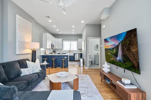 a living room with a couch and a tv on a wall at NYC Skyline Views • Near Times Sq • Rooftop Deck in Jersey City