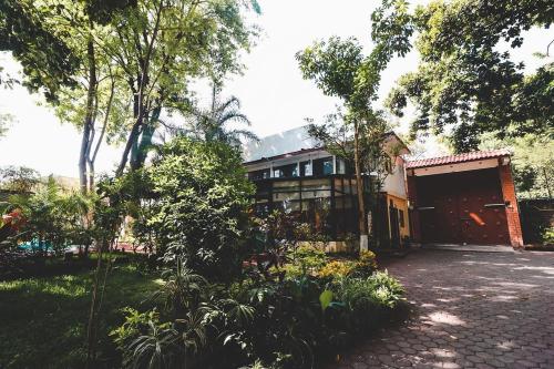 a building with a garage and trees in front of it at Hotel Boutique Canto Del Agua in Chiconcuac
