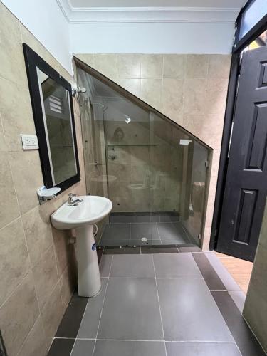 um banheiro com pia e chuveiro com espelho em Finca Fusagasugá Villa Luisa em Fusagasuga