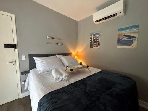 a bedroom with a bed with a tray on it at Moreno Guest House com Piscina, churrasqueira Praia de Itaguaré e Riviera in Bertioga