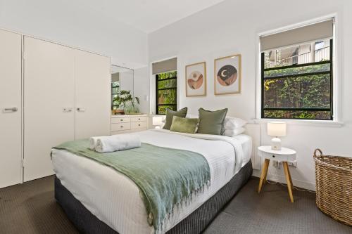 a white bedroom with a large bed and a window at Byron Getaway @the Crest in Byron Bay