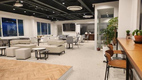 een wachtkamer met tafels en stoelen in een gebouw bij welcalm village in Naemulch'i-ri