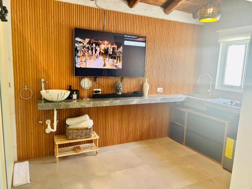 a bathroom with a sink and a tv on a wall at Hotel Villa La Fortuna in Filipina