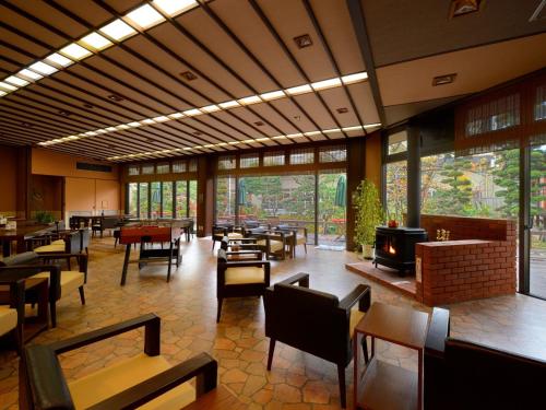 a restaurant with tables and chairs and a fireplace at Sakaeya Hotel in Tendo