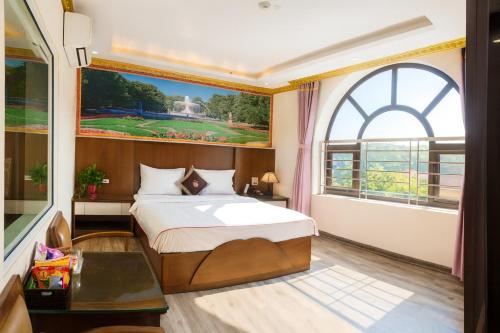Postel nebo postele na pokoji v ubytování Hoàng Gia Long Biên Hotel