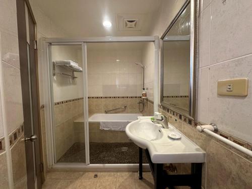 a bathroom with a shower and a sink and a tub at 文化信然 in Tainan