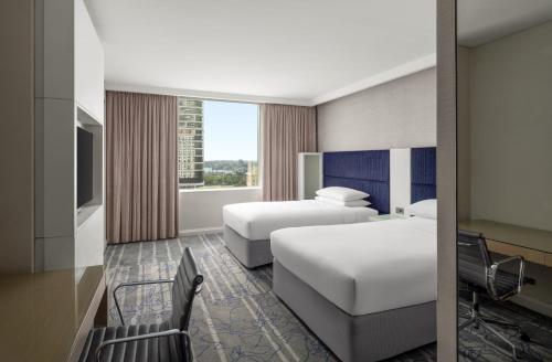 a hotel room with two beds and a window at Sydney Harbour Marriott Hotel at Circular Quay in Sydney
