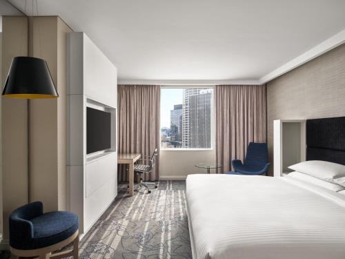 a hotel room with a bed and a tv at Sydney Harbour Marriott Hotel at Circular Quay in Sydney