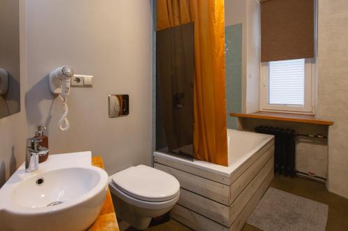 a bathroom with a sink and a toilet and a shower at Baltic Design Apartments with free Parking and self check in in Rīga