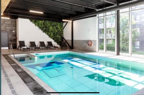 a pool in a building with blue water at Cé La Vie in Quebec City