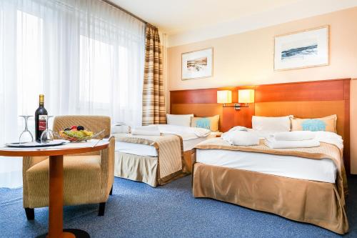 a hotel room with two beds and a table at Hotel Marttel in Karlovy Vary