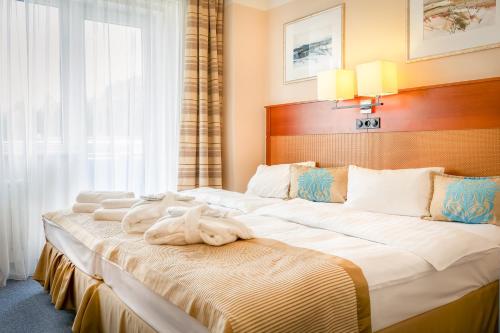 een hotelkamer met 2 bedden en handdoeken erop bij Hotel Marttel in Karlsbad