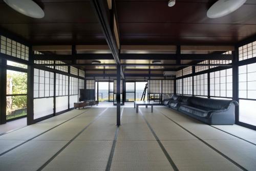 a large room with a couch and windows at Ogoto House Rake Omi in Otsu