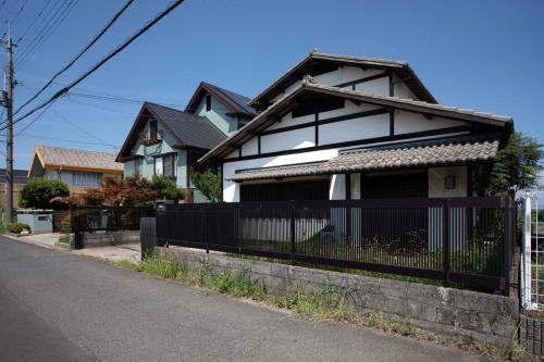a black and white house with a fence at Ogoto House Rake Omi in Otsu