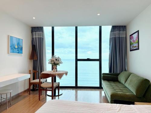 a living room with a green couch and a table at Grands StarCity in Nha Trang