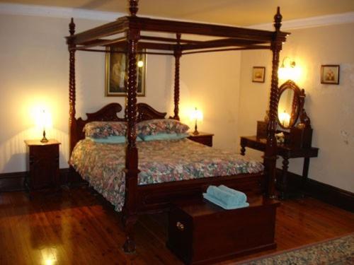 a bedroom with a canopy bed and two lamps at Lochinvar House in Lochinvar