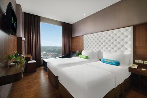 Ένα ή περισσότερα κρεβάτια σε δωμάτιο στο Grand Tebu Hotel
