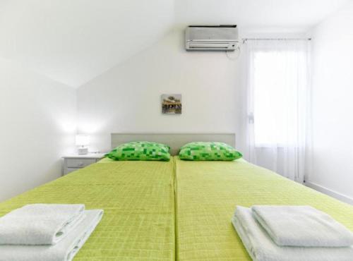 a bedroom with a green bed with two pillows at Villa Kate in Pašman