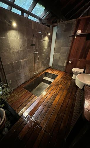 a bathroom with a wooden floor and a bath tub at The Shorea in Seremban