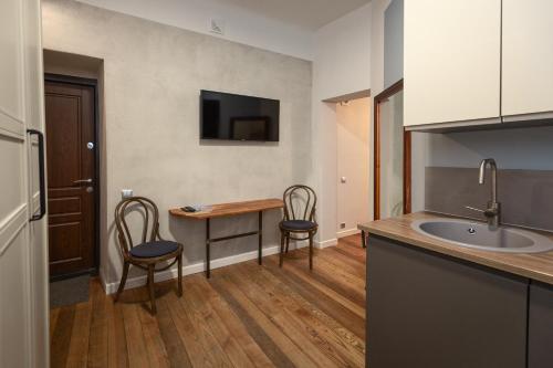 a kitchen with a table and chairs and a sink at Baltic Design Apartments with free Parking and self check in in Rīga