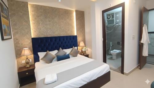 Un dormitorio con una cama grande y un baño. en Hotel Lime Pride Park Near By IGI Airport Delhi, en Nueva Delhi