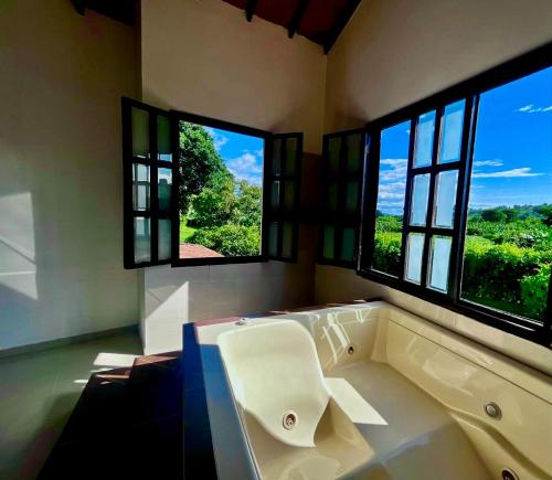 a large bathroom with a tub and two windows at Hotel Campestre Jardín del Café Quindío in Armenia