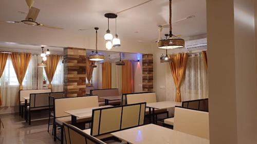 una sala da pranzo con tavoli, sedie e finestre di GLEN RESIDENCY a Chinchinim