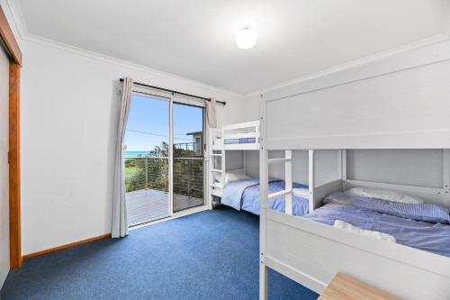 una camera con due letti a castello e un balcone di The Breakers a Sunderland Bay