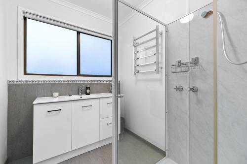 un bagno bianco con lavandino e doccia di The Breakers a Sunderland Bay