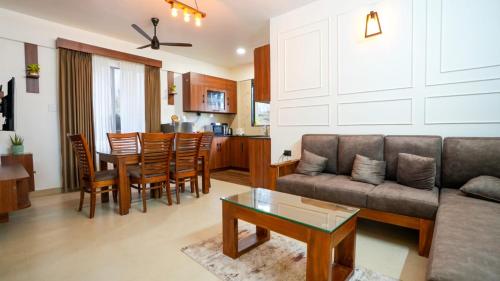 Mizuki Homestay في تريشور: غرفة معيشة بها أريكة وطاولة