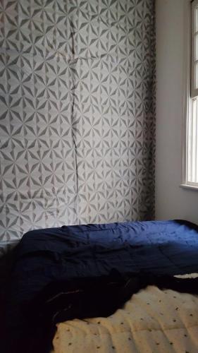 una camera con un letto blu e un muro di Pernoite para rapazes apartamento compartilhado a San Paolo