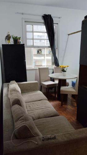 un soggiorno con un divano e un tavolo di Pernoite para rapazes apartamento compartilhado a San Paolo