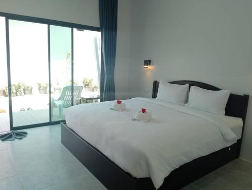 a bedroom with a large white bed with two ducks on it at Naranta House in Ko Raeng