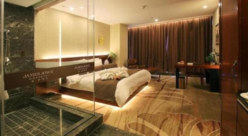 a hotel room with a bed and a glass wall at James Joyce Coffetel Golmud Huaxing Plaza Branch in Golmud