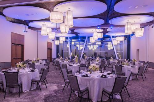a banquet hall with white tables and chairs and chandeliers at The Hotel at Oberlin in Oberlin