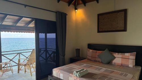 a bedroom with a bed with a view of the ocean at Minang Cove Resort in Tioman Island