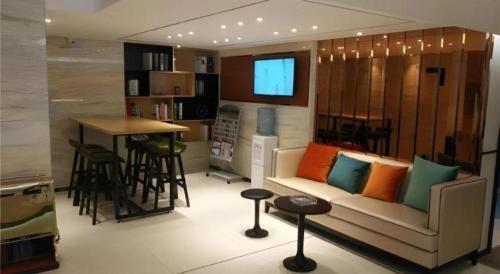 a living room with a couch and a bar at City Comfort Inn Yanji Yanbian University Department Building in Yanji